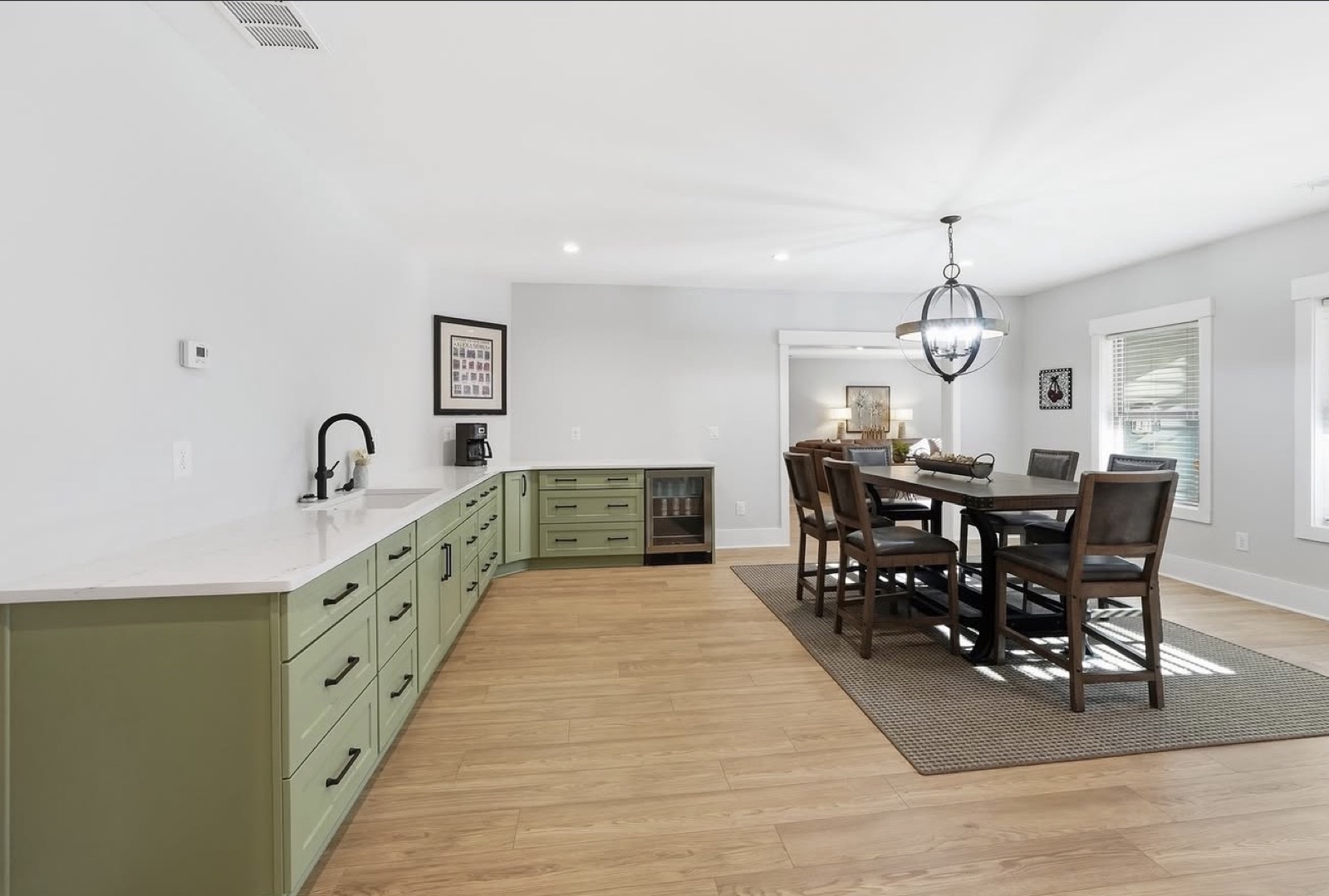 A freshly painted open-plan interior with sage-green cabinetry and warm neutral walls by Elite Finishes